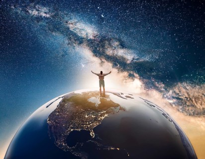 A man stands victoriously atop the Earth amidst a surreal cloudscape, symbolizing triumph over