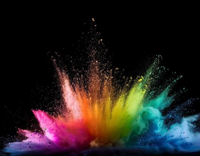 Vibrant and energetic multicolored powder explosion captured against a dark background. Evoking