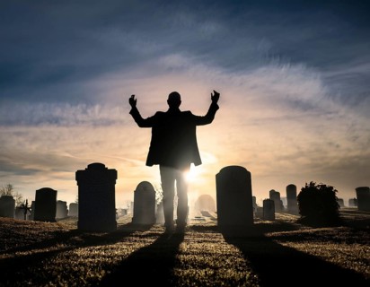 A silhouette of a lone figure walking off a gravestone, The scene evokes Resurrection thoughts