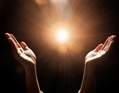 Image of open hands embracing a radiant light source, embodying concepts of hope, spirituality, and
