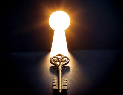 An antique key, leading to a bright light in a keyhole shape, symbolizing opportunity, access, and