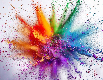 Vibrant and energetic multicolored powder explosion captured against awhite background. Evoking