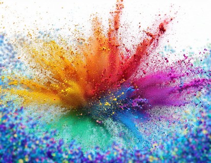 Vibrant and energetic multicolored powder explosion captured against awhite background. Evoking