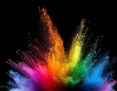 Vibrant and energetic multicolored powder explosion captured against a dark background. Evoking