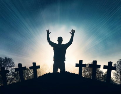 A silhouette of a lone figure walking off a gravestone, The scene evokes Resurrection thoughts