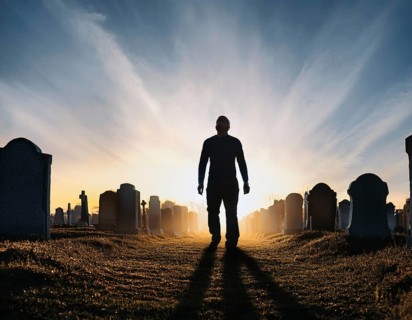 A silhouette of a lone figure walking off a gravestone, The scene evokes Resurrection thoughts