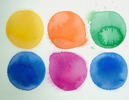 Colorful watercolor circles painted on a white background create a vibrant and artistic design.