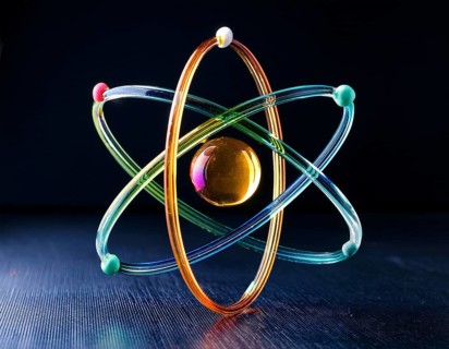 A vibrant illustration of an atomic structure with colorful spheres and connections, illuminated