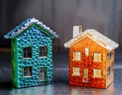 A collection of small glass model houses with cozy lighting, creating a warm and inviting