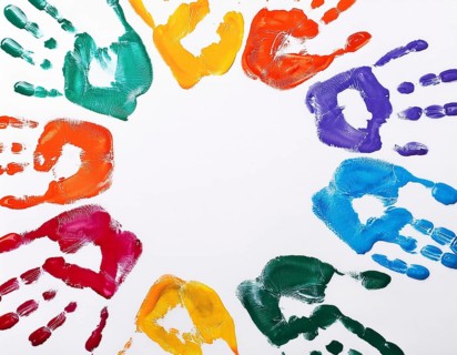 Brightly colored handprints in various hues arranged artistically on a textured white surface,