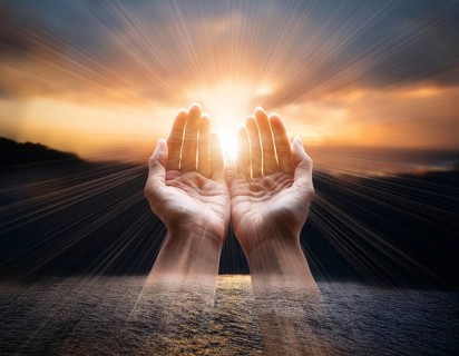Image of open hands embracing a radiant light source, embodying concepts of hope, spirituality, and