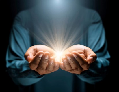 Individual Worship at Home. Image of open hands embracing a radiant light source, embodying