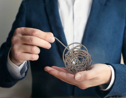 A close-up of a professional ipresenting a piece of intricate, tangled wire, symbolizing