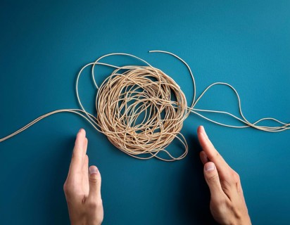 A close-up of a professional ipresenting a piece of intricate, tangled wire, symbolizing