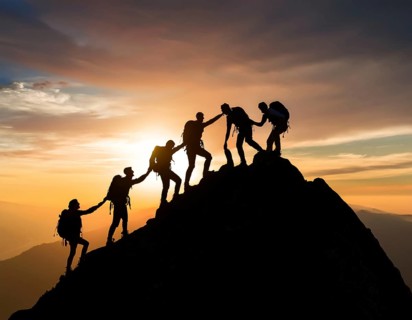 A dynamic depiction of teamwork and determination, climbers ascend a rugged mountain peak during