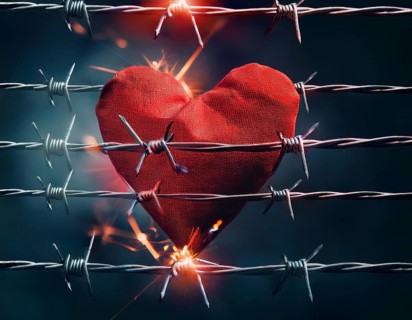 A symbolic depiction of a red heart entwined in barbed wire, set against a blurred warm-toned bokeh