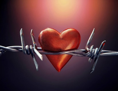 A symbolic depiction of a red heart entwined in barbed wire, set against a blurred warm-toned bokeh