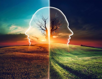 A miniature house and bare tree on cracked soil with a vivid orange sunset, symbolizing