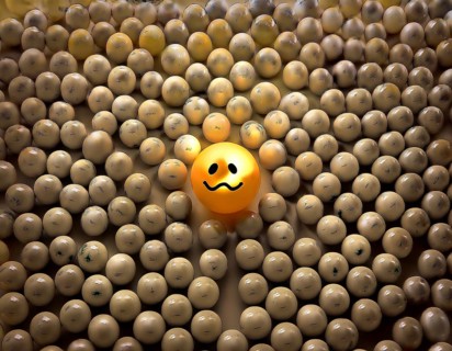 Wooden balls feature faces, one smiling among sad expressions, representing positivity or