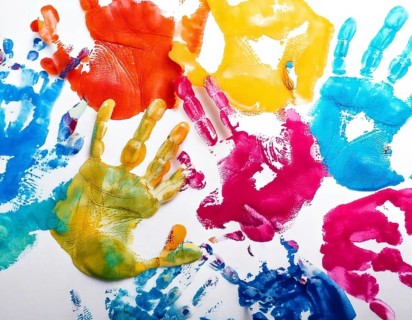 Vibrant multicolored handprints on white background, symbolizing creativity, playful expression,