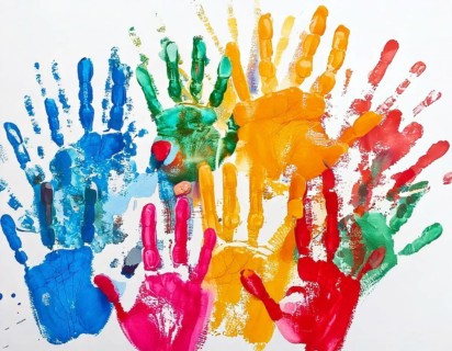 Vibrant multicolored handprints on white background, symbolizing creativity, playful expression,