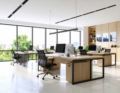 Modern coworking space with laptops, coffee cups, plants, and daylight showcasing minimal interior