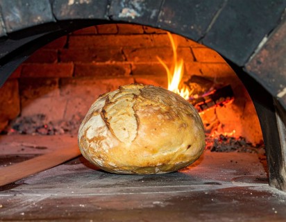 Fresh baked bread steaming on rustic wooden background, symbolizing artisanal baking, tradition,