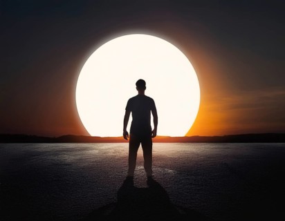 Man silhouette against giant glowing sun symbolizing inspiration, destiny, reflection, cosmic