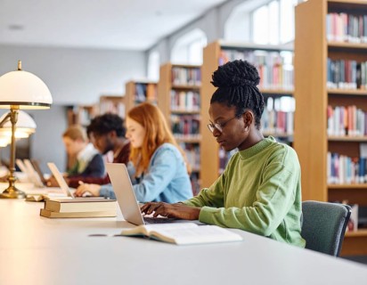 University students studying with open books and laptops, symbolizing education, collaborative