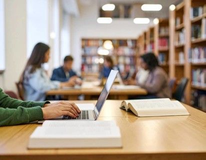 University students studying with open books and laptops, symbolizing education, collaborative