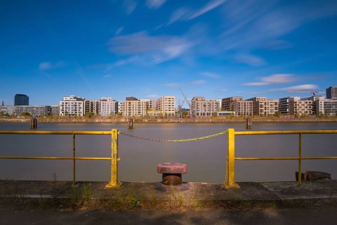 View over a harbour basin to a part of the Hamburg Hafencity in the foreground a yellow railing