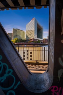Long-term photograph of the mirror building through a steel girder of the Oberhafenbrücke bridge at