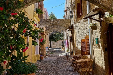Idyllic, flower-filled alleyway with arches and old stone buildings in historic style, Turkish