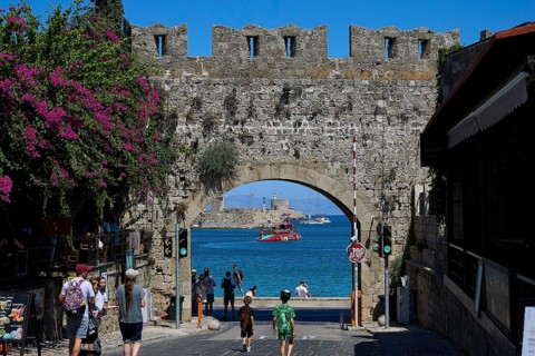 Panagia Tor, natural stone archway with a view of the sea and passing tourists, Rhodes Old Town,