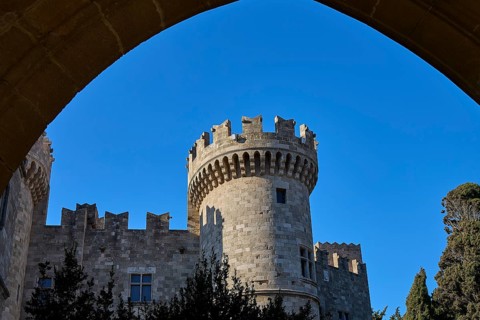 Tor tor Grand Master's Palace, castle with imposing tower and battlements, framed by a strong blue