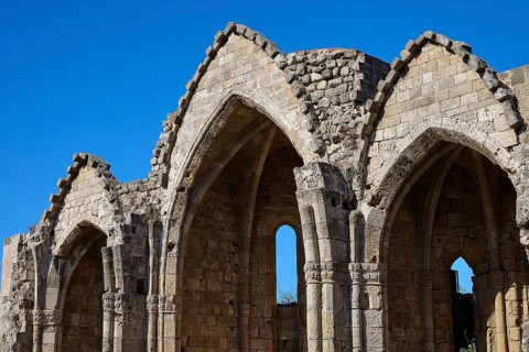 Church of Virgin Mary of the Castle, Gothic ruins with striking arches under a clear blue sky,