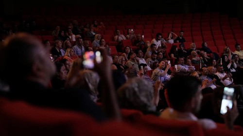 Audience members dance and clap as Turkish singer Coskun Sabah performs during the Türkiye Kültür