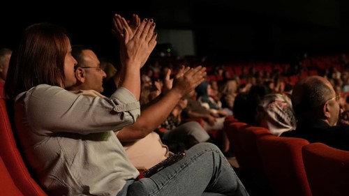 Audience members dance and clap as Turkish singer Coskun Sabah performs during the Türkiye Kültür