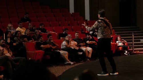 Audience members dance and clap as Turkish singer Coskun Sabah performs during the Türkiye Kültür