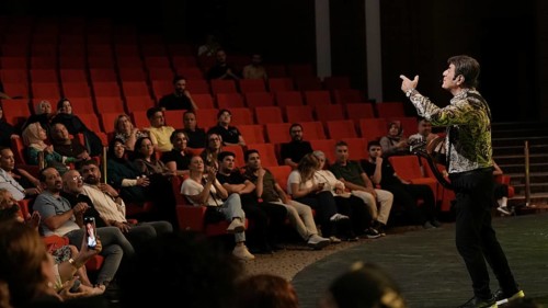 Audience members dance and clap as Turkish singer Coskun Sabah performs during the Türkiye Kültür