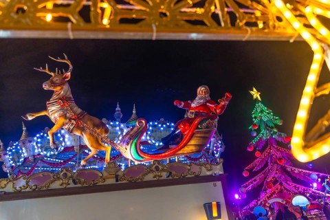 Santa claus figurine waving on a sleigh pulled by a reindeer at the bayonne christmas market in