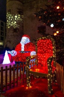 Luminous santa claus installation sitting on his throne during christmas festivities in bayonne,