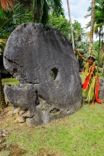 Local boy in traditional traditional costume from Yap Island as size comparison next to oversized