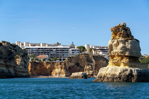 Praia Dona Ana beach, hotel buildings, Ponta da Piedade rocky coast, rugged coastal landscape,