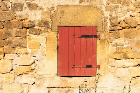 Red wooden window, historic house façade, yellow sandstone, Marville, Renaissance village,