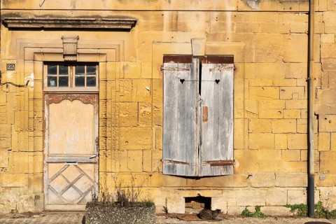 Closed wooden door and windows, historic house façade, yellow sandstone, Marville, Renaissance