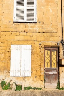 Closed door and white wooden window, historic house façade, yellow sandstone, Marville, Renaissance