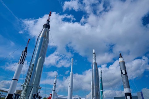 Various rockets rising into the blue sky, surrounded by clouds, Kennedy Space Centre Visitor
