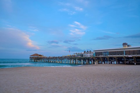 A quiet beach with a long wooden pier under a blue evening sky, Westgate Cocoa Beach Pier, Cocoa