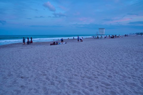 People enjoying the beach at dusk under a blue sky, Cocoa Beach, Port Canaveral, Florida, USA